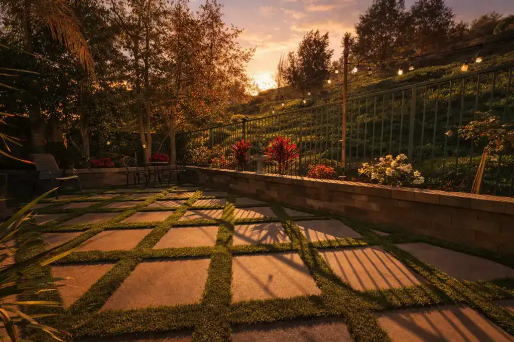 Square concrete patio pavers with artificial turf strips