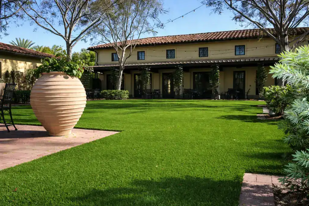 A large Spanish-style courtyard with a perfectly manicured artificial turf lawn 