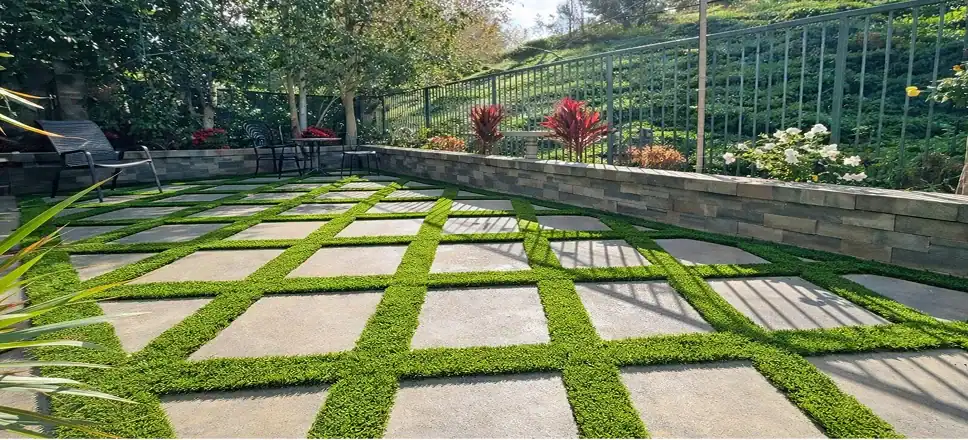 Backyard patio with concrete pavers, artificial turf, retaining wall, and landscape design for a modern outdoor living space