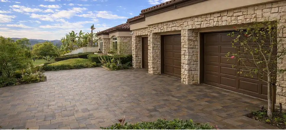 Custom paver driveway with stone exterior and landscaped entry designed for a luxury Southern California home