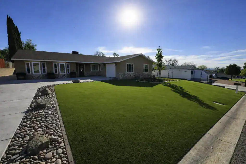 Front yard with artificial grass lawn, clean edging, and enhanced curb appeal