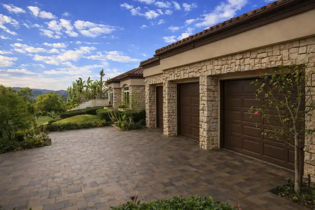 luxurious residential property with a stone facade and a spacious paver driveway