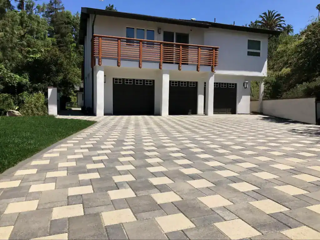 modern two-story house with a large driveway made of interlocking pavers.