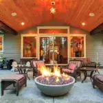Custom covered patio with built-in fire pit and outdoor seating designed for backyard living