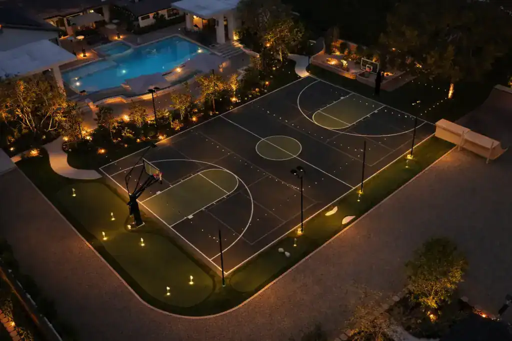 Ecoworkz backyard basketball court with landscape lighting and outdoor recreation area